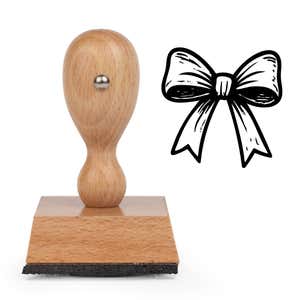 Festive Gift Bow Craft Stamp standing upright beside its black stamped festive gift bow image