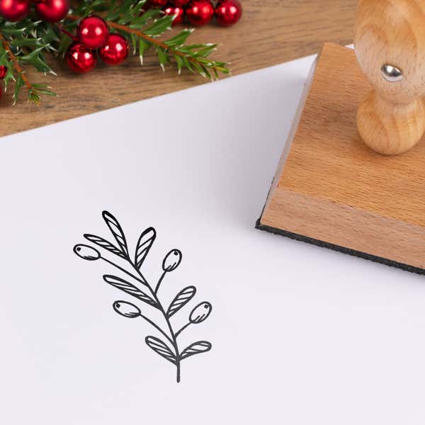Cheerful holiday sprig stamped in black on white cardstock styled with red berries and pine greenery