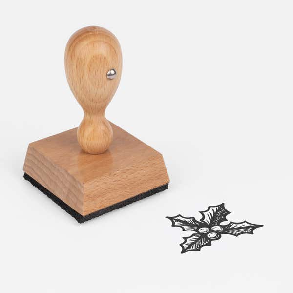 Evergreen Holly Craft Stamp at an angle, showing the wooden handle, square block and stamped evergreen holly