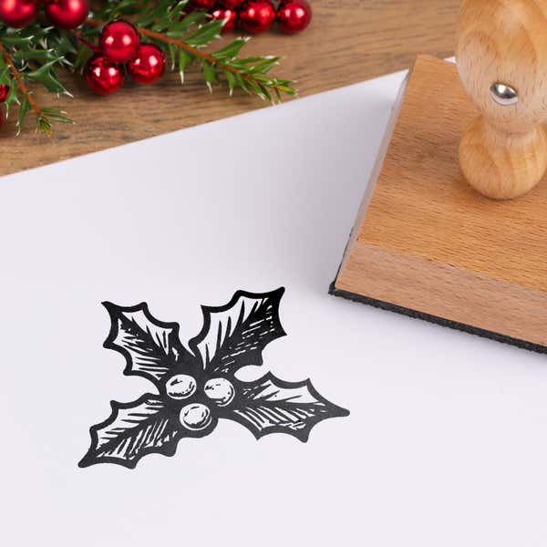 Evergreen holly stamped in black on white cardstock styled with red berries and pine greenery