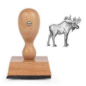 Woodland Moose Craft Stamp standing upright beside its black stamped engraved moose image