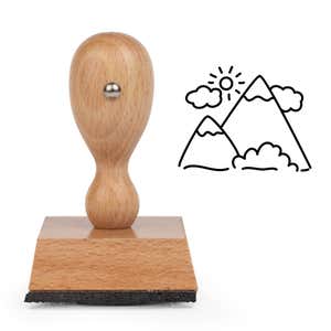 Mountain Landscape Craft Stamp standing upright beside its black stamped mountain landscape image