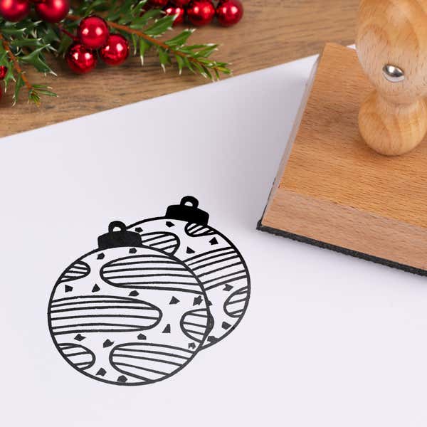 Keepsake tree ornaments stamped in black on white cardstock styled with red berries and pine greenery
