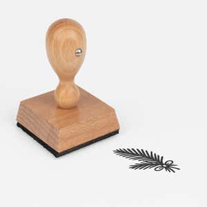 Woodland Pine Branch Craft Stamp at an angle, showing the wooden handle, square block and stamped woodland pine branch