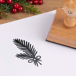 Woodland pine branch stamped in black on white cardstock styled with red berries and pine greenery