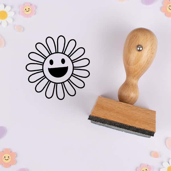Beaming sunburst flower stamped in black on lavender cardstock with smiling daisy confetti