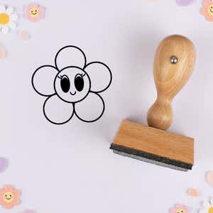 Wide-eyed flower stamped in black on lavender cardstock with smiling daisy confetti