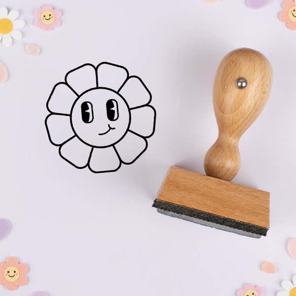 Vintage cartoon flower stamped in black on lavender cardstock with smiling daisy confetti