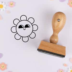 Sly glance flower stamped in black on lavender cardstock with smiling daisy confetti