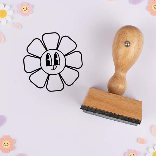Crooked smile flower stamped in black on lavender cardstock with smiling daisy confetti