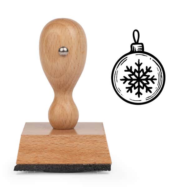 Winter Snowflake Ornament Craft Stamp standing upright beside its black stamped winter snowflake ornament image