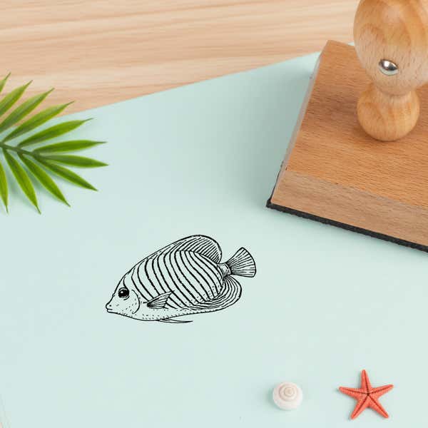 tropical fish stamped in black on pale mint cardstock with a green palm frond, a small spiral shell and a red starfish