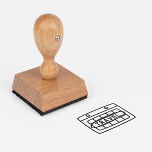 Travel Graphic Craft Stamp at an angle with its wooden handle and block