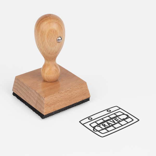 Travel Graphic Craft Stamp at an angle with its wooden handle and block