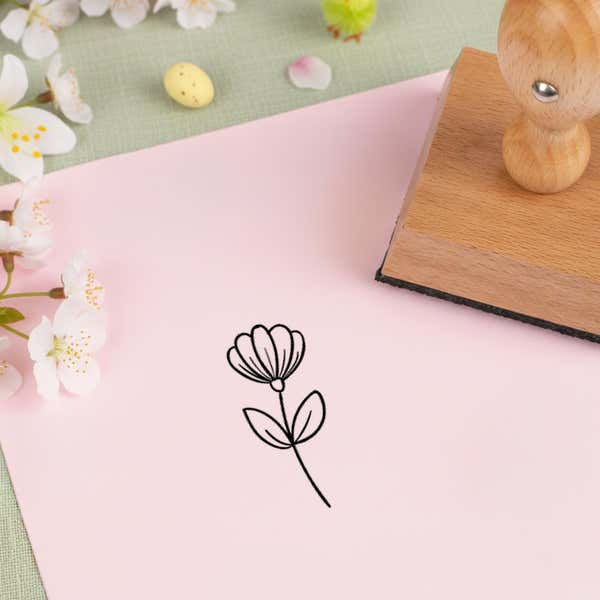 garden tulip stamped in black on pink cardstock beside white blossoms, a speckled candy egg and the wooden stamp