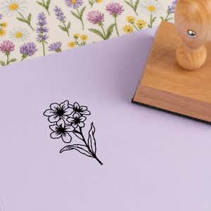 Clustered blossom spray stamped in black on lilac cardstock on wildflower-print fabric