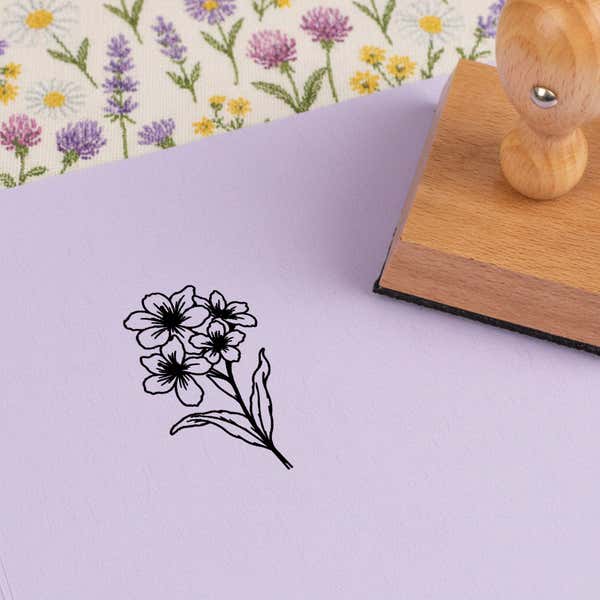 Clustered blossom spray stamped in black on lilac cardstock on wildflower-print fabric