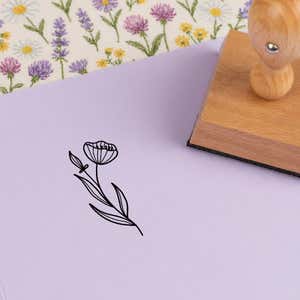 Veined cup wildflower stamped in black on lilac cardstock on wildflower-print fabric
