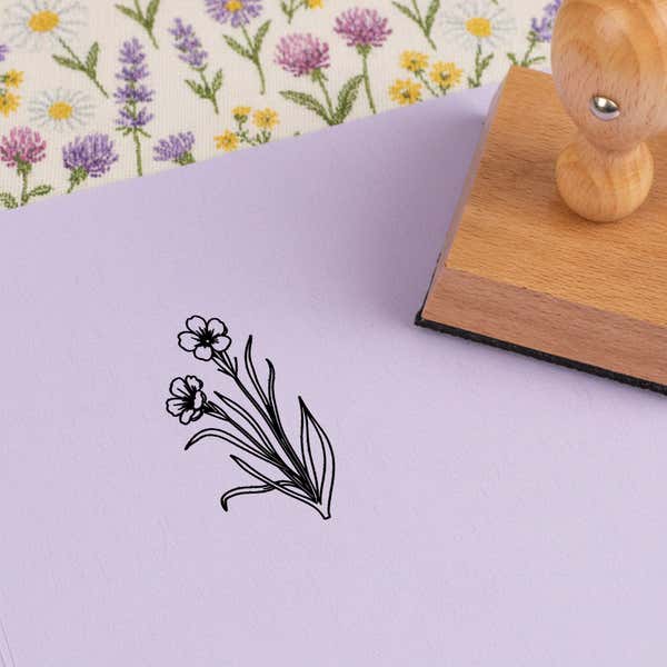 Grassy wildflower bunch stamped in black on lilac cardstock on wildflower-print fabric