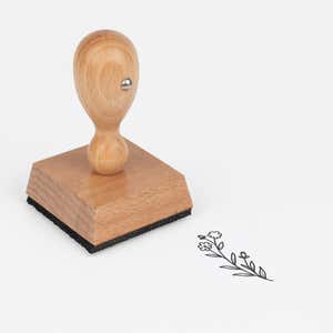 Little Blossom Sprig Craft Stamp at an angle with its wooden handle and block