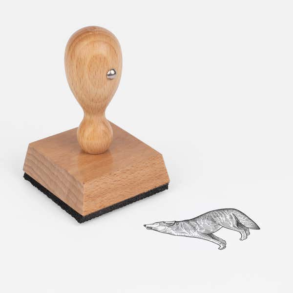 Woodland Wolf Craft Stamp at an angle with its wooden handle and block