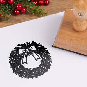 Seasonal Christmas wreath stamped in black on white cardstock styled with red berries and pine greenery