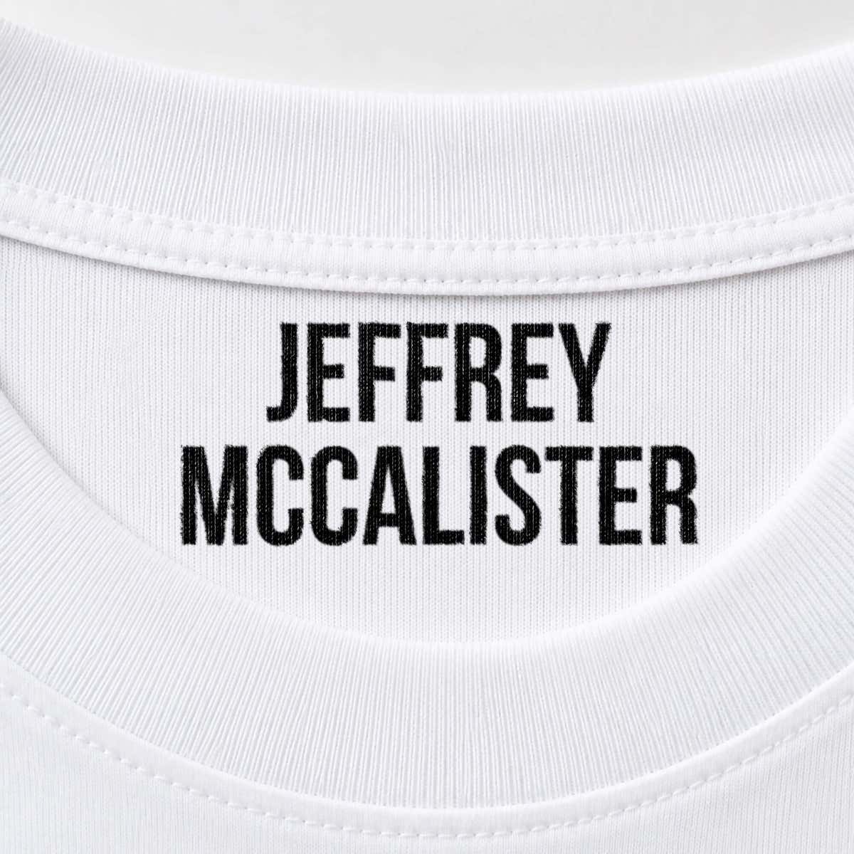 Close-up of a name stamped inside a white t-shirt collar in the Bold font, a heavy condensed all-caps print.