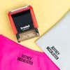 A pink shirt and a gray sock name-stamped in the Bold font, a heavy condensed all-caps print, beside a Trodat clothing stamp, on a yellow background.