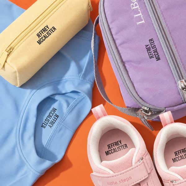 Kids' pencil case, shirt, lunch bag and sneakers name-stamped in the Bold font, a heavy condensed all-caps print, with a SimplyStamps clothing stamp.