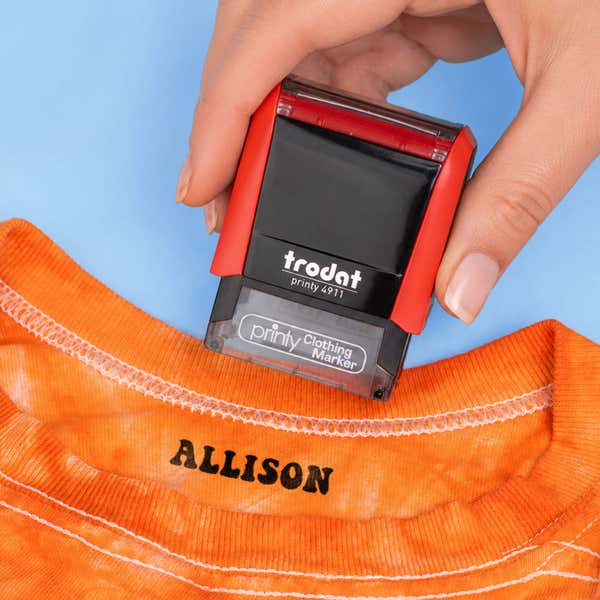 Hand pressing the Retro Clothing Stamp onto a t-shirt to show clean impression