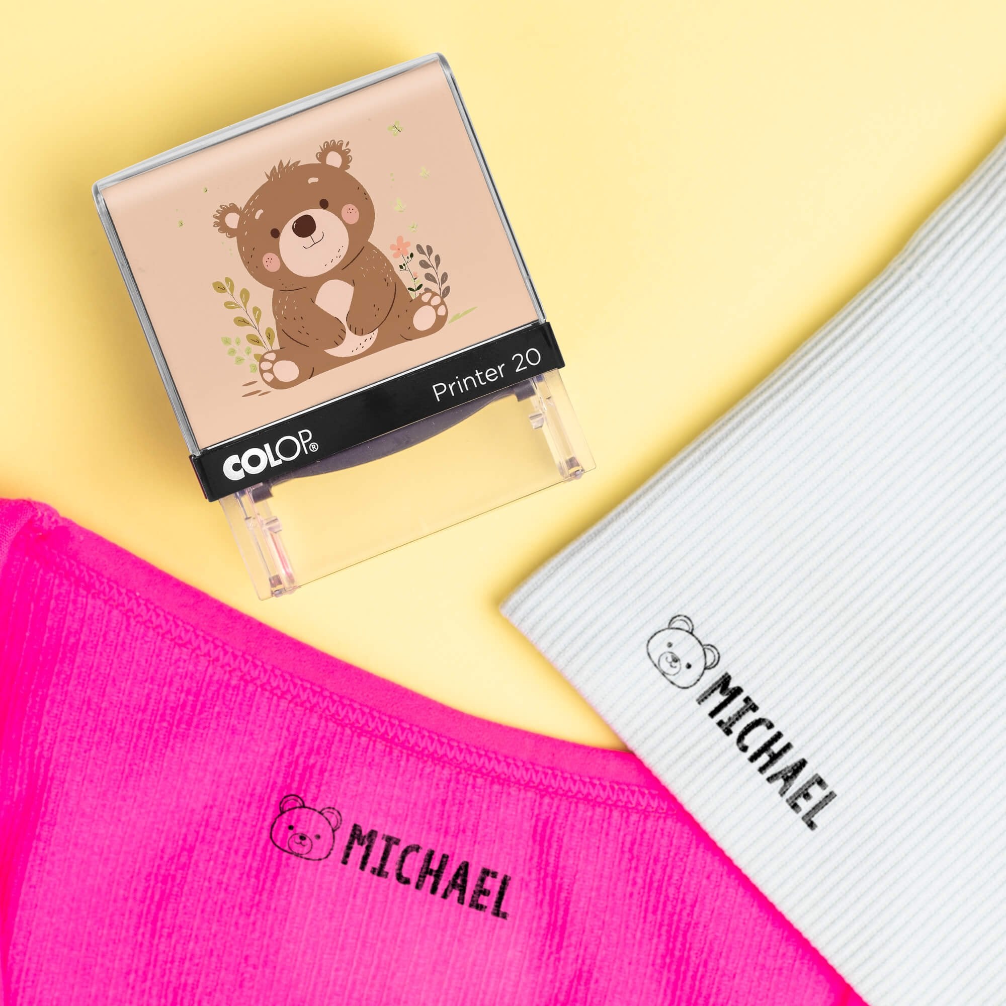 Bear clothing name stamp beside pink and light gray shirts labeled Michael