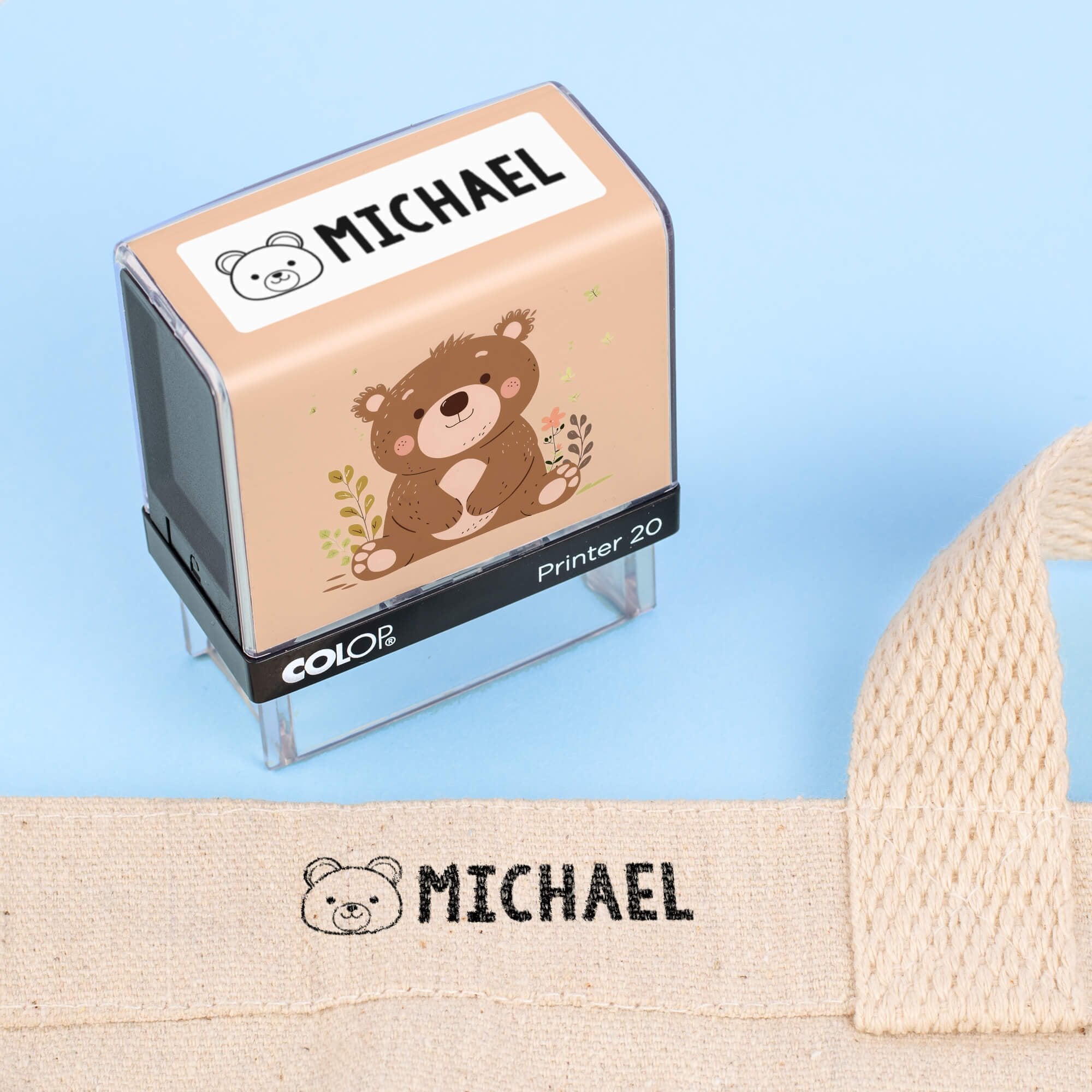 Bear clothing name stamp beside a canvas tote bag labeled Michael