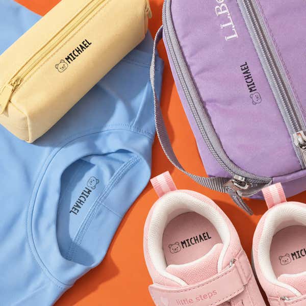 Bear name stamp impressions on a pencil case, lunch bag, blue shirt and pink shoes