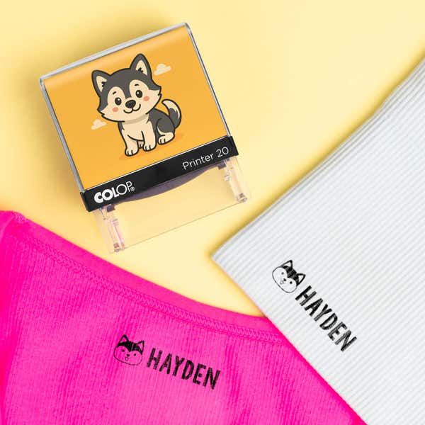 Dog clothing name stamp beside pink and light blue shirts labeled Hayden