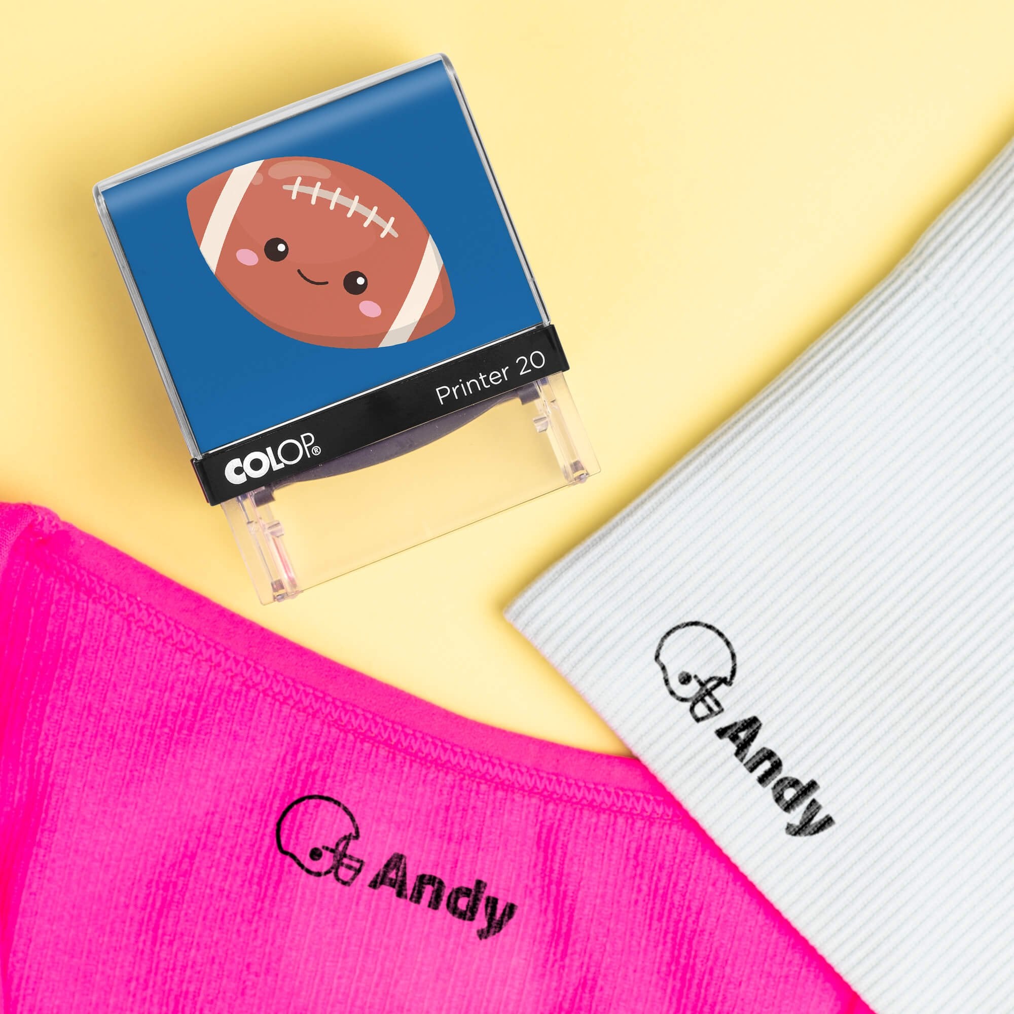 Football clothing name stamp beside pink and light gray shirts labeled Andy
