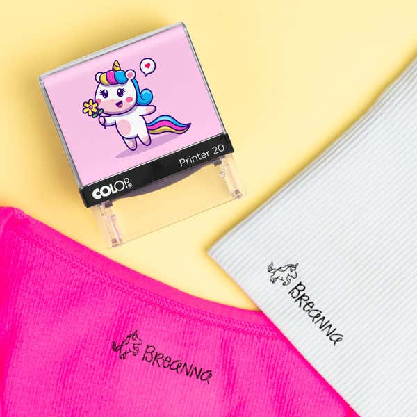 Pink unicorn clothing stamp beside pink and white shirts labeled Breanna