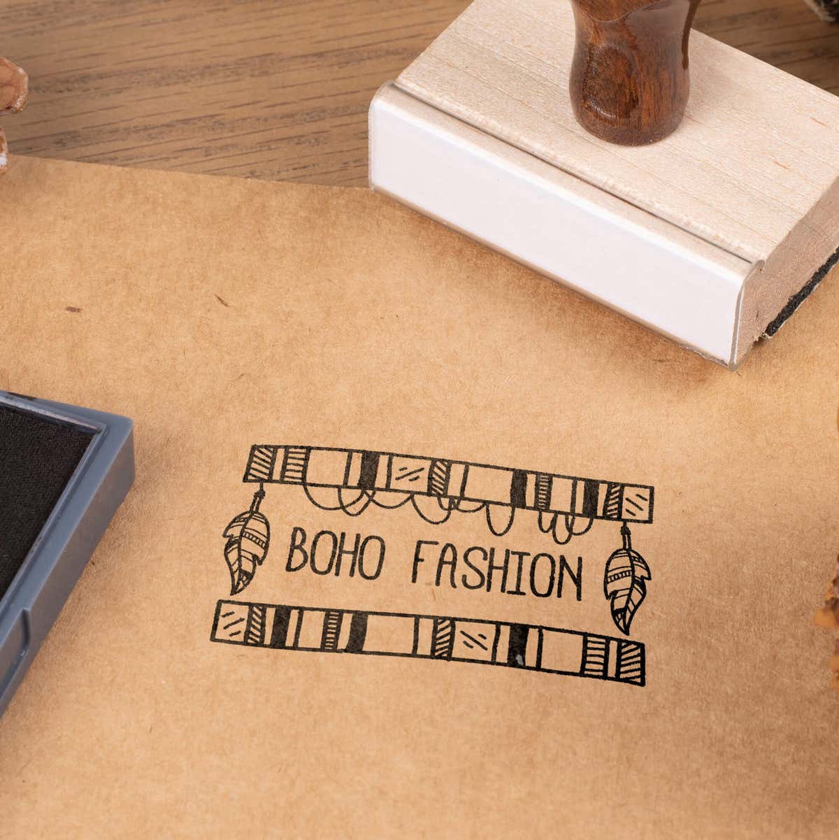 Wood handle logo stamp making boho fashion impression on kraft paper