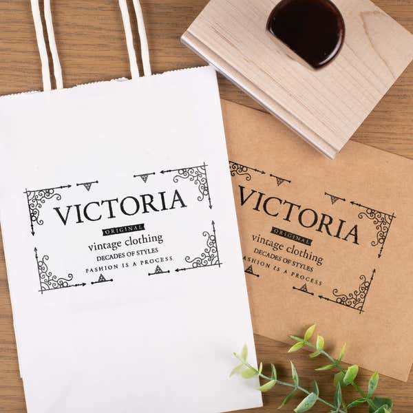 Wooden rubber stamp imprinting business logo on paper bags