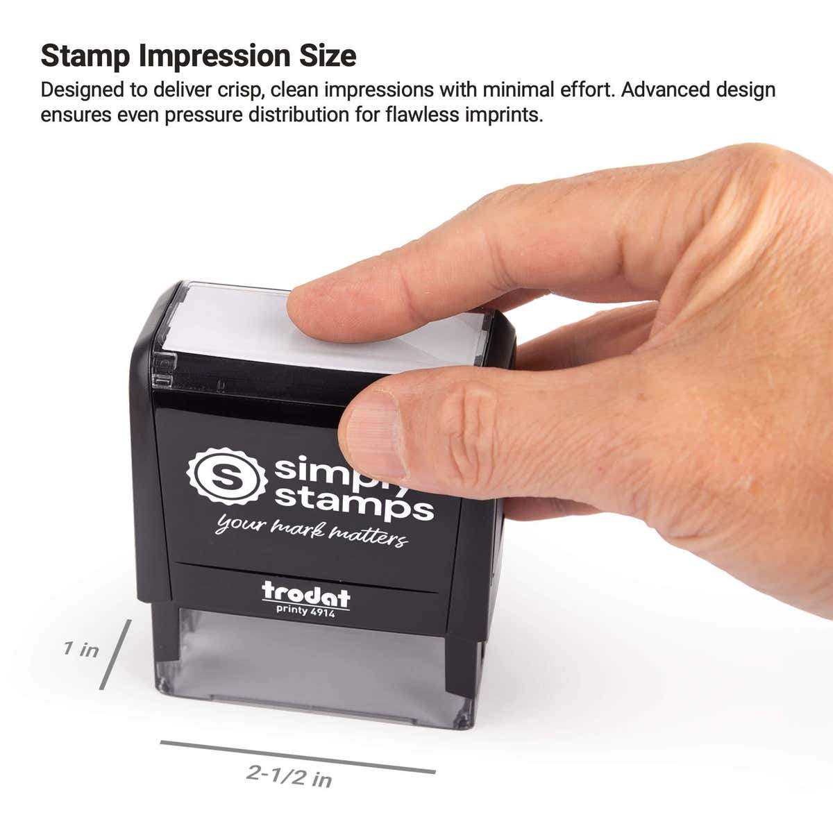 Close-up image of hand pressing a self-inking stamp showing 1 inch by 2.5 inch impression area for clear stamping results.