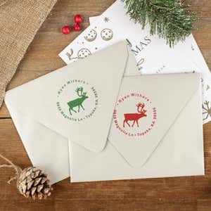 Green and red ink impressions of ‘Holiday Reindeer Custom’ return address stamp on Christmas envelopes.