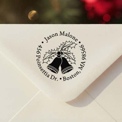 Personalized ‘Holly Bells Holiday’ address stamp impression on envelope flap for holiday cards.