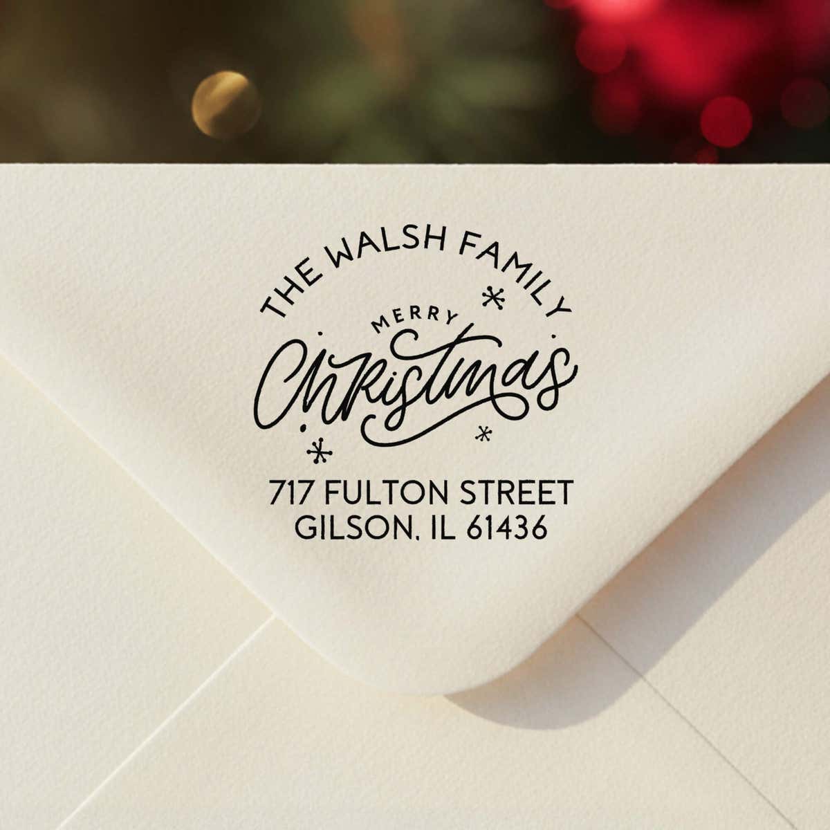 Personalized ‘Merry Christmas with Snowflakes’ address stamp impression on envelope flap for holiday cards.