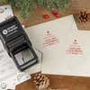 Holiday-themed ‘Display Christmas Tree’ address stamp shown on envelopes beside festive stationery, pinecones, and decorations.