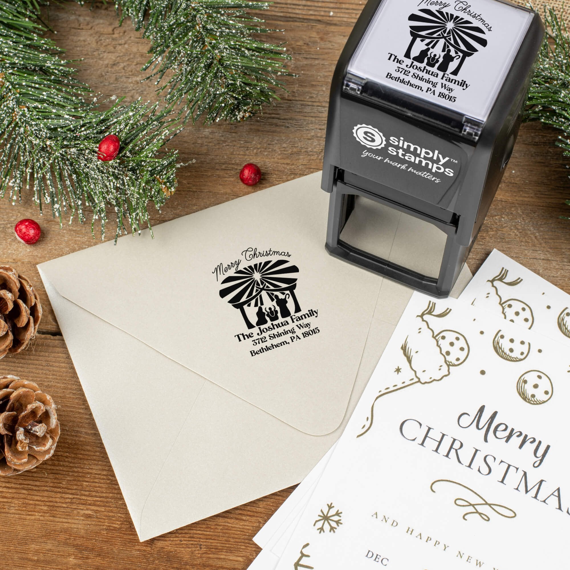 Holiday-themed ‘Nativity Scene’ address stamp shown on envelopes beside festive stationery, pinecones, and decorations.