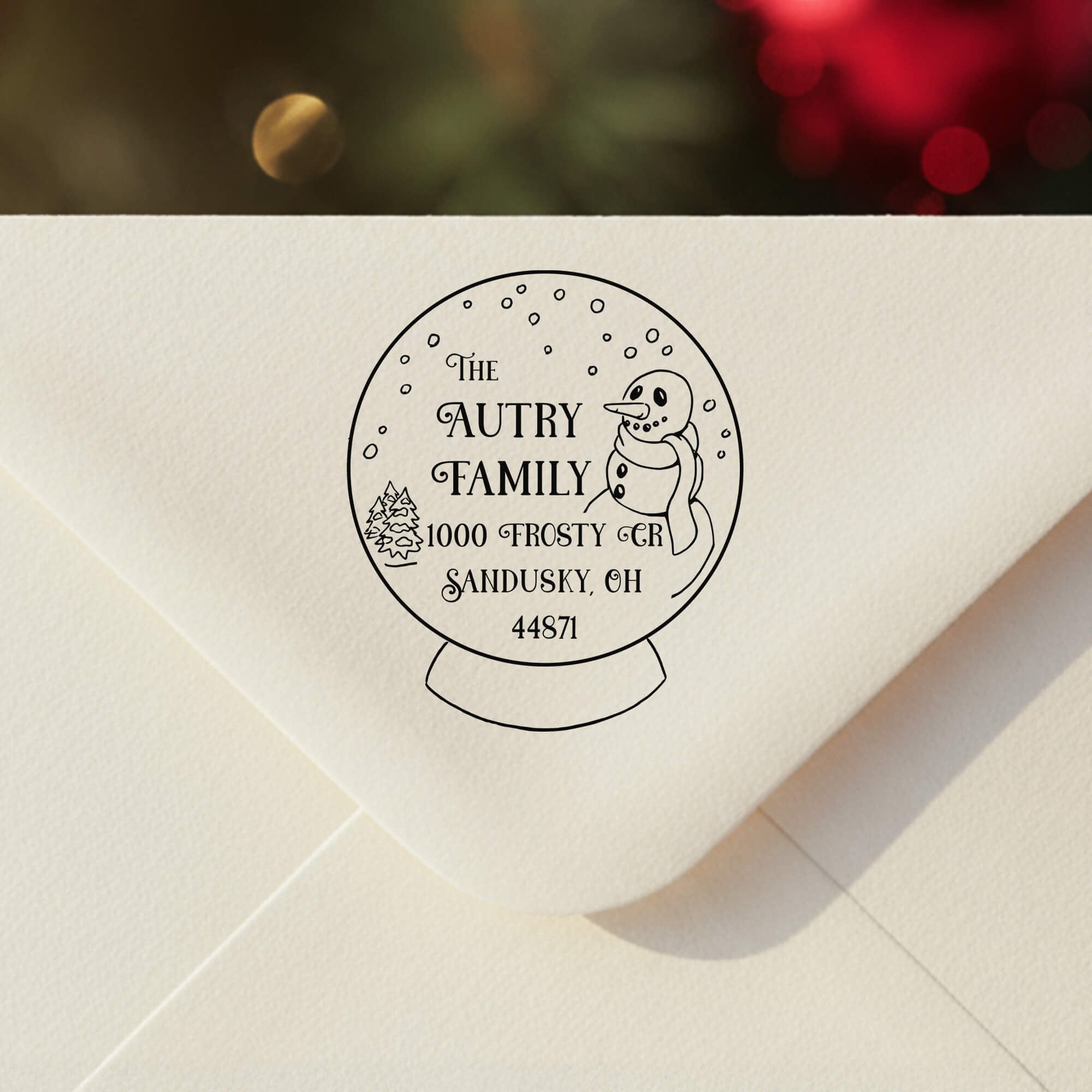 Personalized ‘Snow Globe’ address stamp impression on envelope flap for holiday cards.