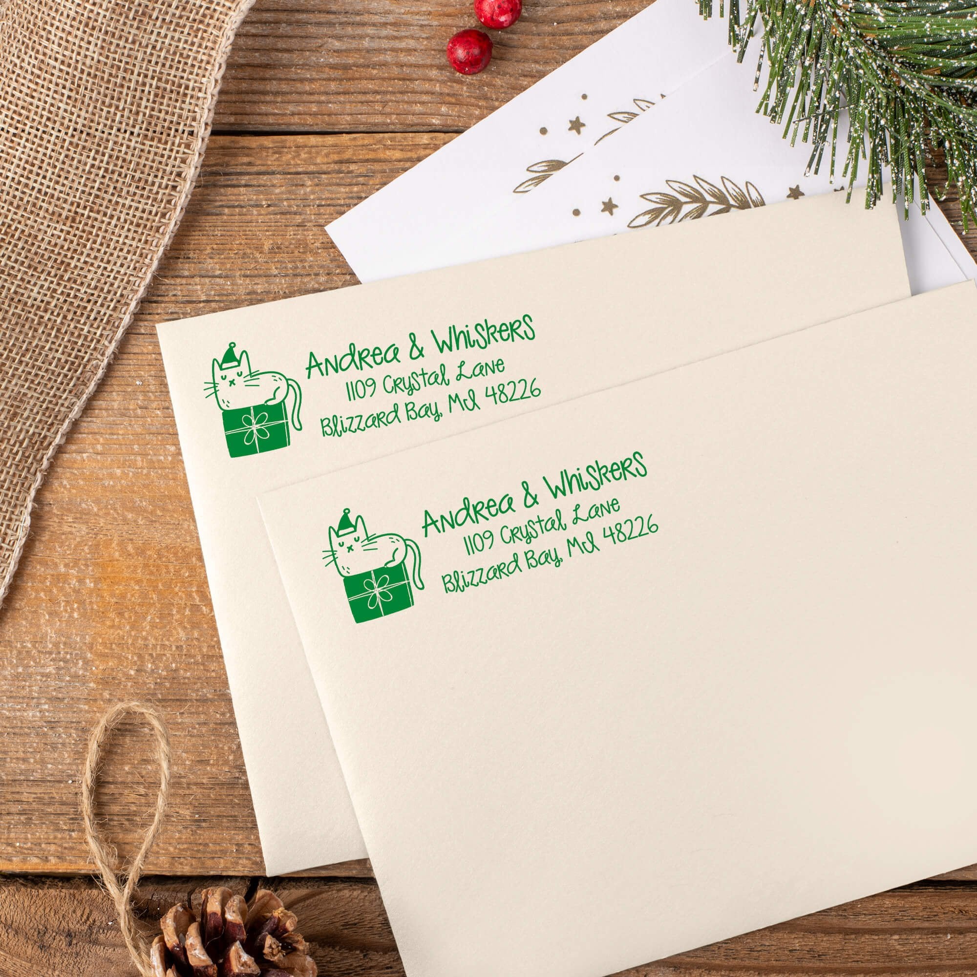 Green ink impressions of ‘Holiday Cat’ return address stamp on Christmas envelopes.