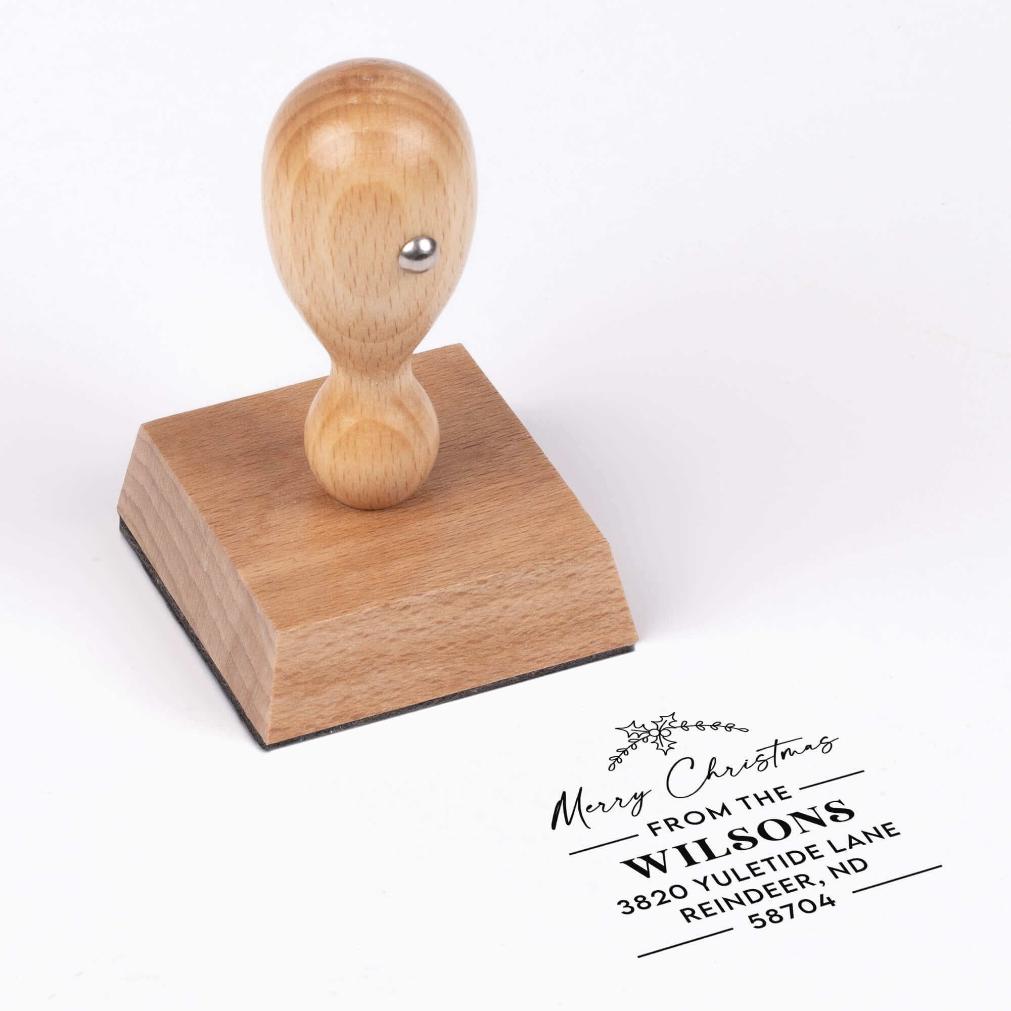 European wood hand stamp shown from above featuring custom ‘Merry Christmas’ holiday return address design.