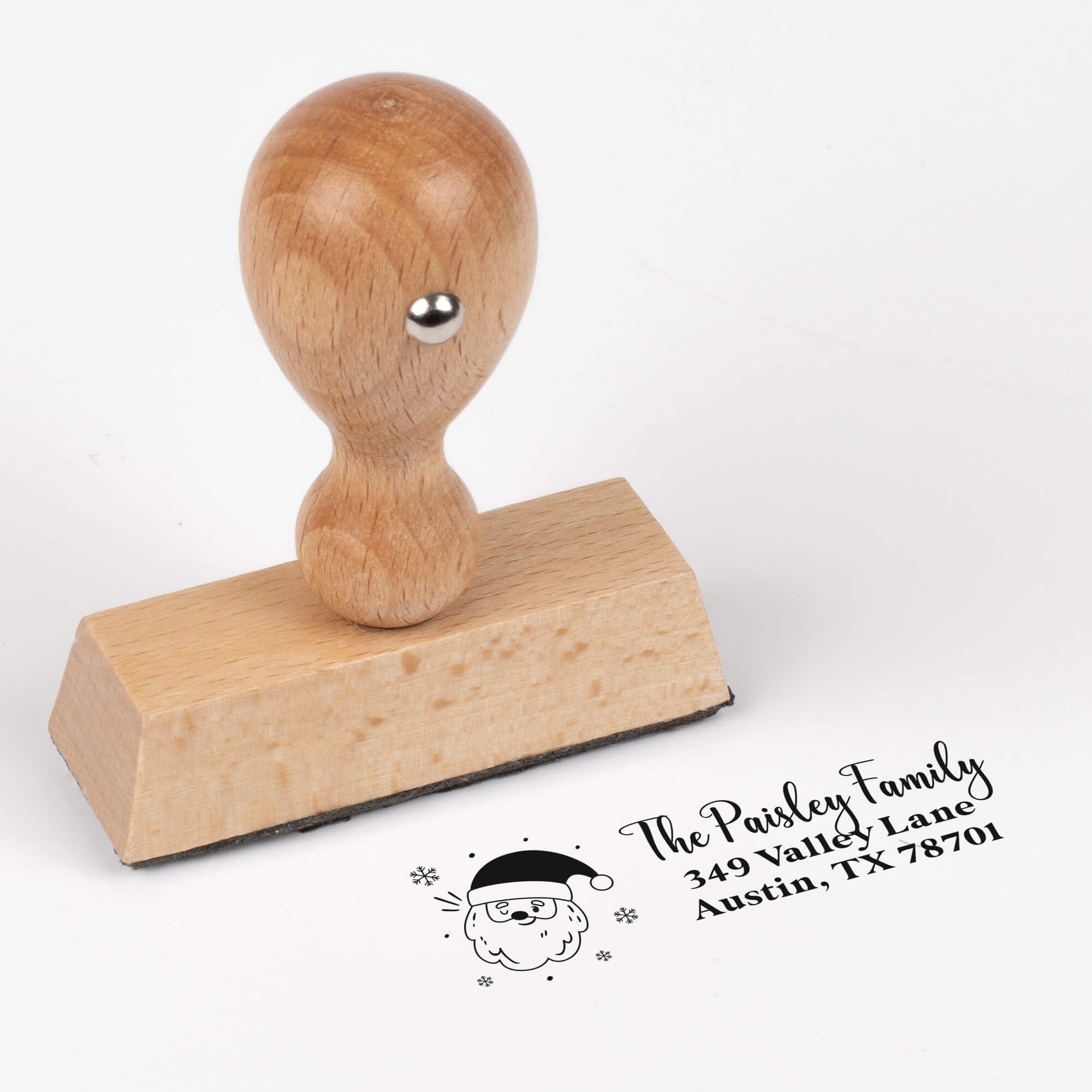 European wood hand stamp shown from above featuring custom ‘Santa Claus’ holiday return address design.
