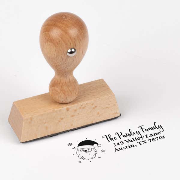 European wood hand stamp shown from above featuring custom ‘Santa Claus’ holiday return address design.