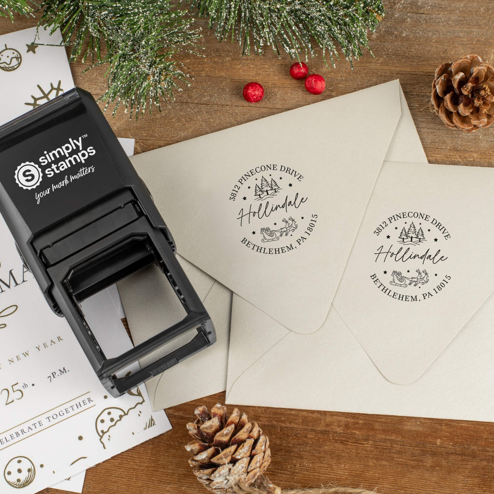 Holiday-themed ‘Santa Sleigh Round’ address stamp shown on envelopes beside festive stationery, pinecones, and decorations.